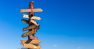 Signpost with blank arrows on blue sky background